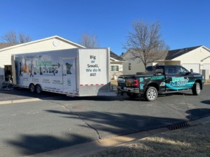 Unique Movers truck and trailer doing a residential move